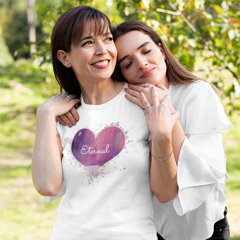 Couple smiling wearing black Love is in the Heart t-shirts.